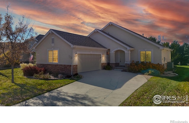 ranch-style house featuring a lawn, central AC unit, and a garage