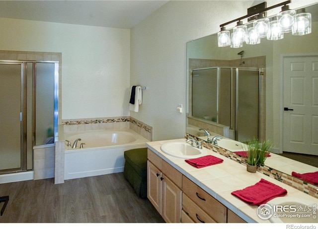 bathroom featuring plus walk in shower, hardwood / wood-style floors, and vanity