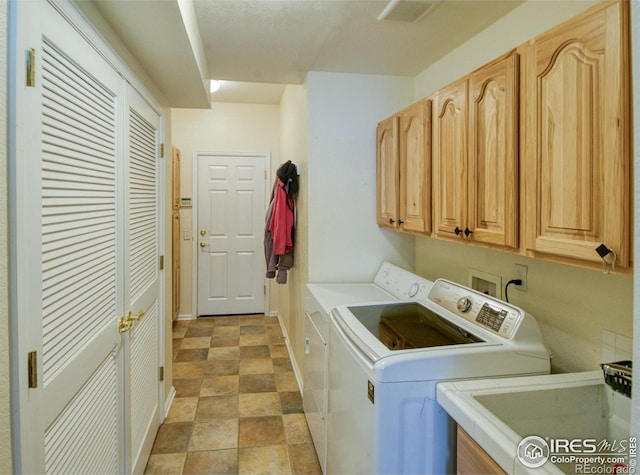 washroom featuring cabinets, sink, and washing machine and dryer