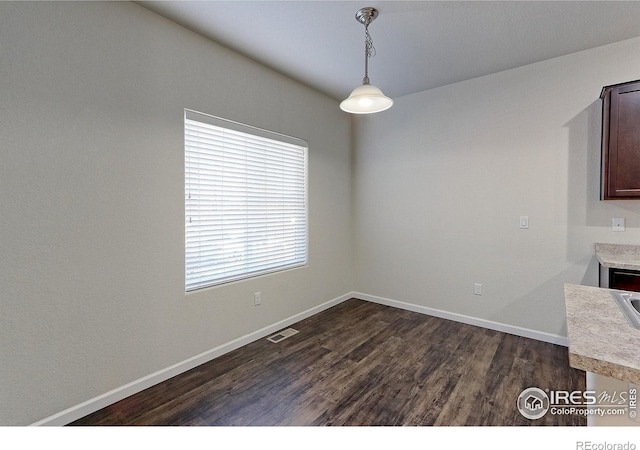 unfurnished dining area with dark hardwood / wood-style flooring