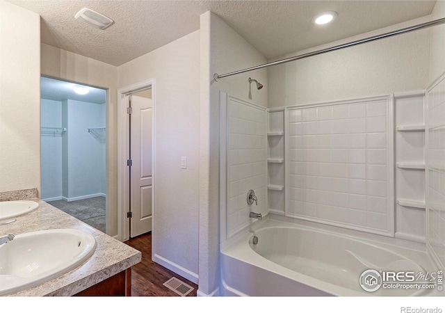 bathroom featuring shower / washtub combination, vanity, a textured ceiling, and hardwood / wood-style flooring