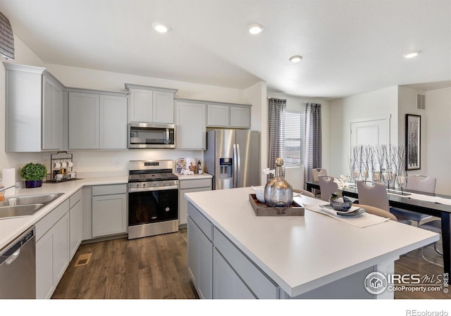 kitchen with a center island, dark hardwood / wood-style flooring, stainless steel appliances, and gray cabinetry