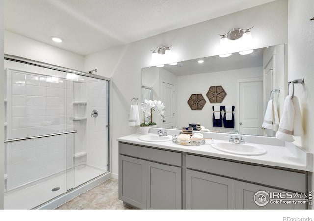 bathroom with tile patterned flooring, a textured ceiling, vanity, and a shower with door