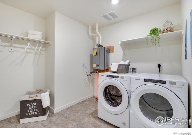 laundry area featuring washing machine and clothes dryer and tankless water heater