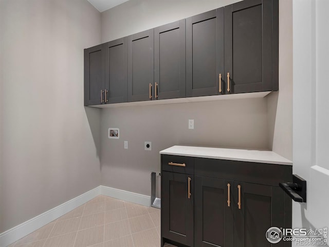 laundry area with baseboards, washer hookup, light tile patterned floors, cabinet space, and electric dryer hookup