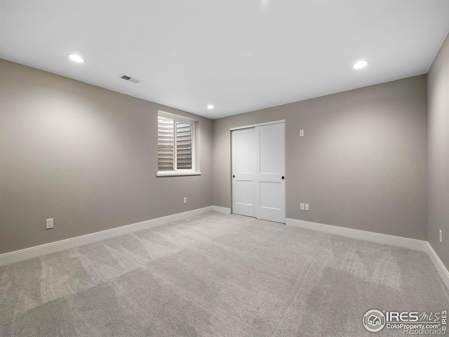 empty room featuring visible vents, recessed lighting, light colored carpet, and baseboards