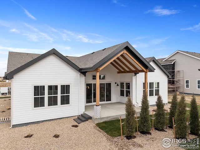 rear view of property with a patio area and a shingled roof