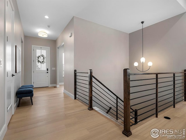 entrance foyer with light hardwood / wood-style flooring and a notable chandelier