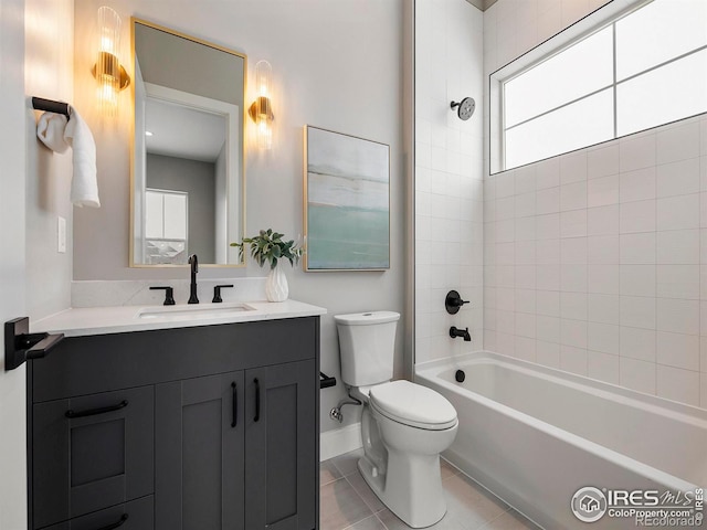 bathroom featuring toilet, vanity, tile patterned flooring, baseboards, and shower / bathtub combination