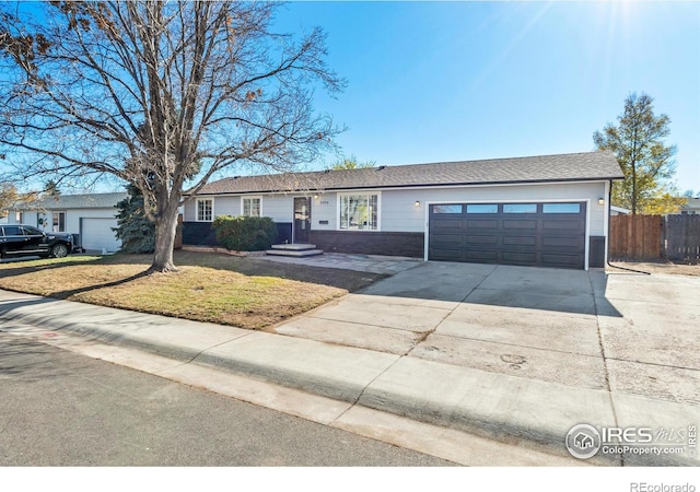 ranch-style house featuring a garage and a front lawn