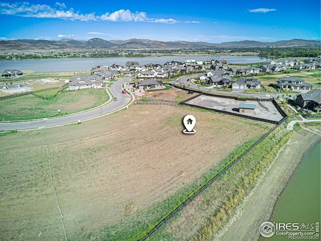 birds eye view of property with a water and mountain view