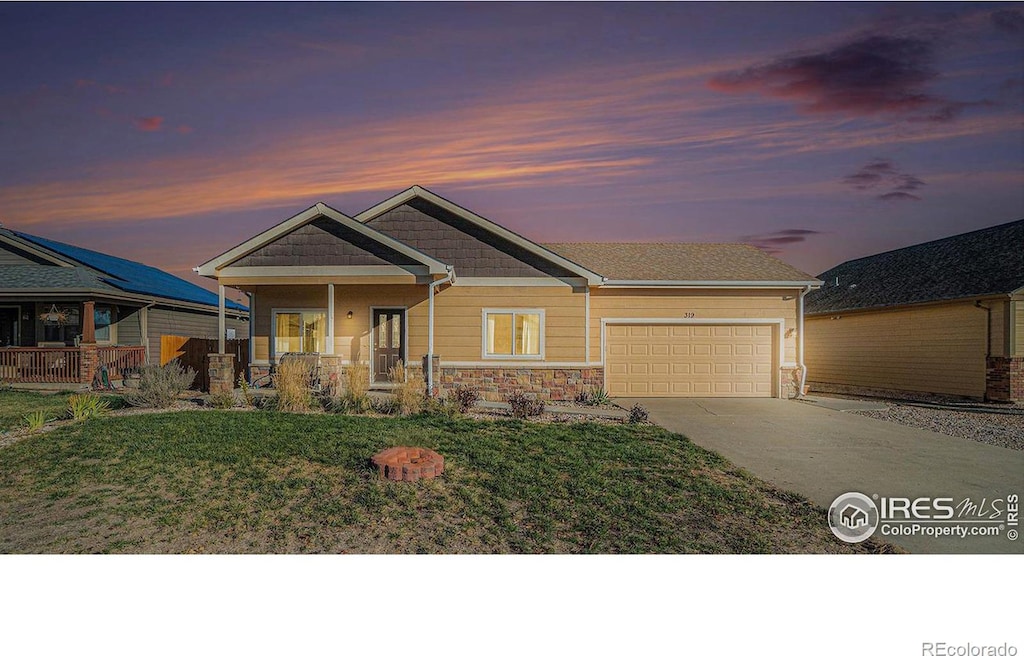 craftsman-style house with a garage, covered porch, and a yard