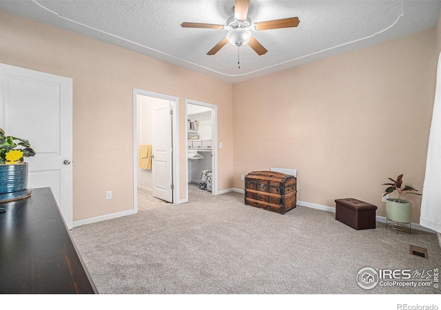 interior space featuring light carpet, a textured ceiling, and ceiling fan