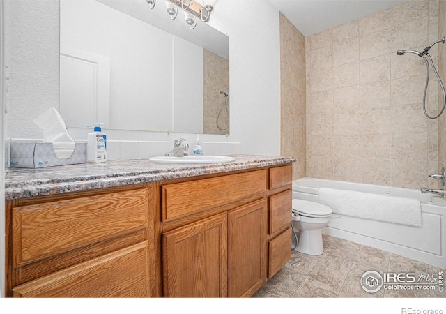 full bathroom featuring vanity, tiled shower / bath combo, and toilet