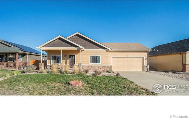 craftsman-style house featuring covered porch, a garage, and a front lawn