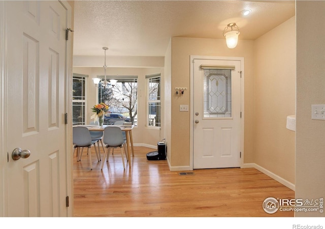 entryway featuring a textured ceiling and light wood-type flooring