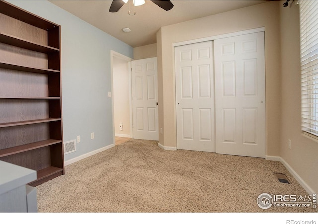 unfurnished bedroom featuring carpet, ceiling fan, and a closet