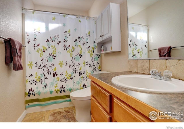 bathroom featuring a wealth of natural light, tile patterned flooring, vanity, and toilet