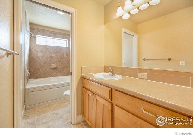 full bathroom featuring vanity, decorative backsplash, tiled shower / bath combo, toilet, and a textured ceiling