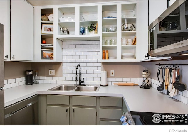 kitchen featuring glass insert cabinets, appliances with stainless steel finishes, light countertops, and a sink