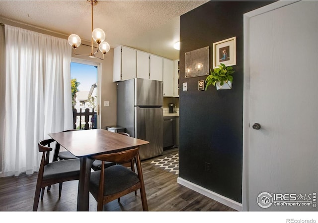 kitchen with a textured ceiling, dark wood-style flooring, white cabinets, light countertops, and freestanding refrigerator