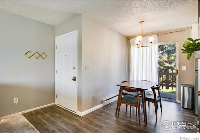 dining room with dark wood finished floors, a notable chandelier, a textured ceiling, and baseboards