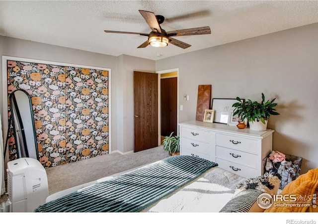 bedroom featuring carpet floors, ceiling fan, and a textured ceiling