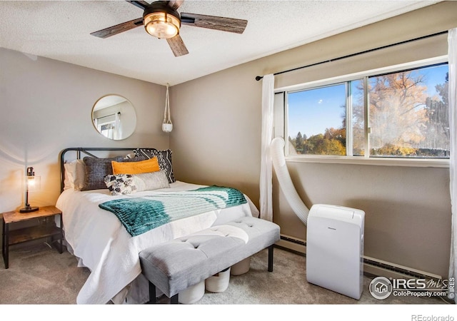 carpeted bedroom featuring baseboard heating, ceiling fan, and a textured ceiling