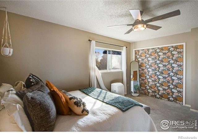 bedroom with carpet flooring, ceiling fan, and a textured ceiling