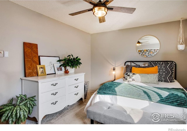 bedroom with carpet, a textured ceiling, and ceiling fan