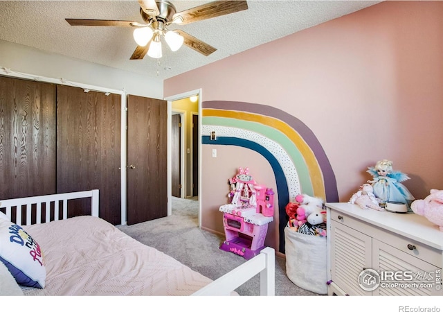 bedroom with a closet, light carpet, ceiling fan, and a textured ceiling