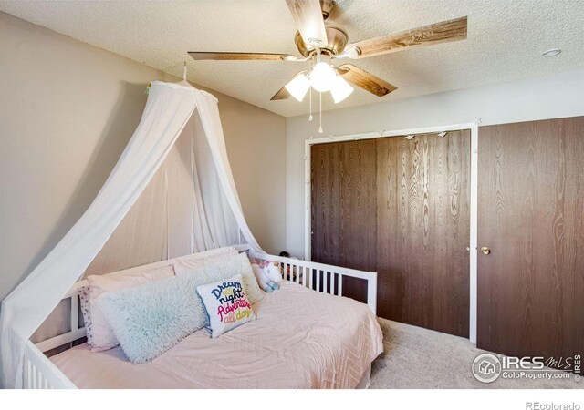 bedroom with carpet, ceiling fan, and a textured ceiling