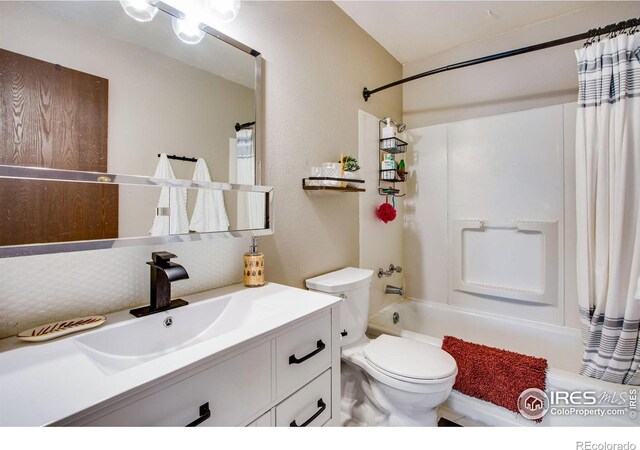 full bathroom featuring shower / bath combination with curtain, toilet, and vanity