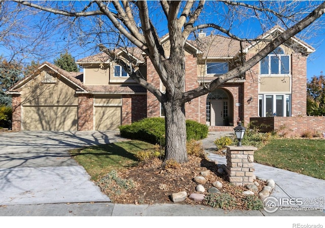 378 High Pointe Dr, Fort Collins, CO 80525 - traditional-style house featuring brick siding, concrete driveway, fence, and a tiled roof