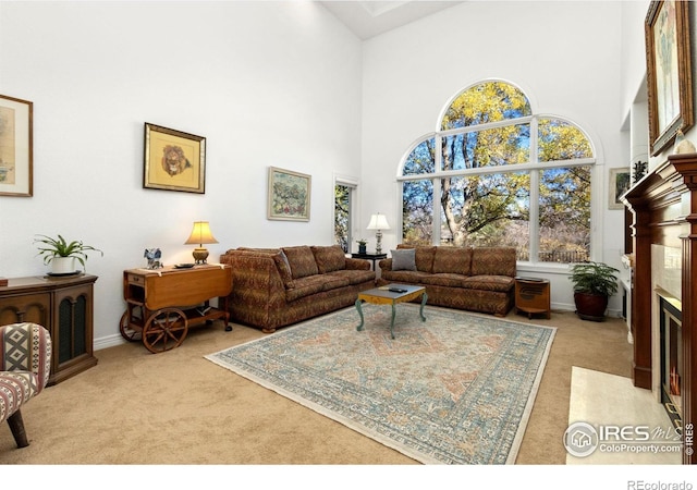 carpeted living room with a towering ceiling