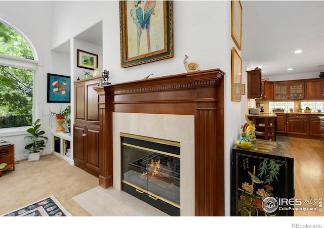 interior space featuring a tile fireplace and light carpet