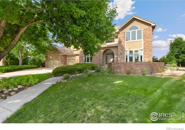378 High Pointe Dr, Fort Collins, CO 80525 - view of front of house featuring driveway, a front yard, a garage, stucco siding, and brick siding