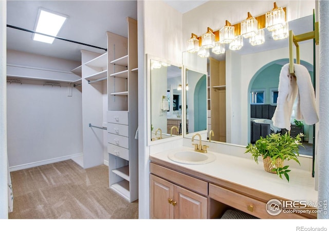 378 High Pointe Dr, Fort Collins, CO 80525 - bathroom featuring a spacious closet, vanity, a chandelier, and baseboards