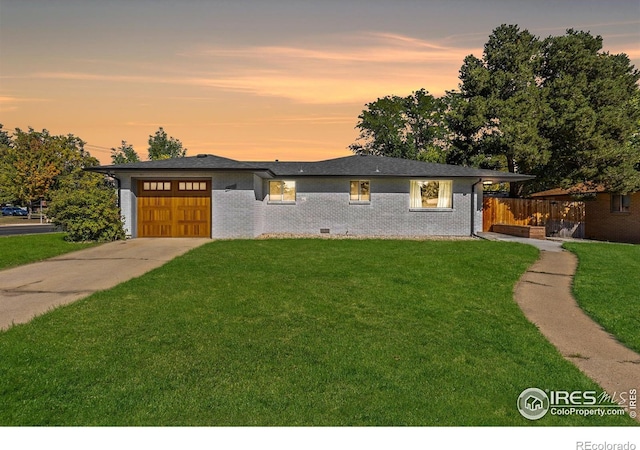 prairie-style house featuring a yard and a garage