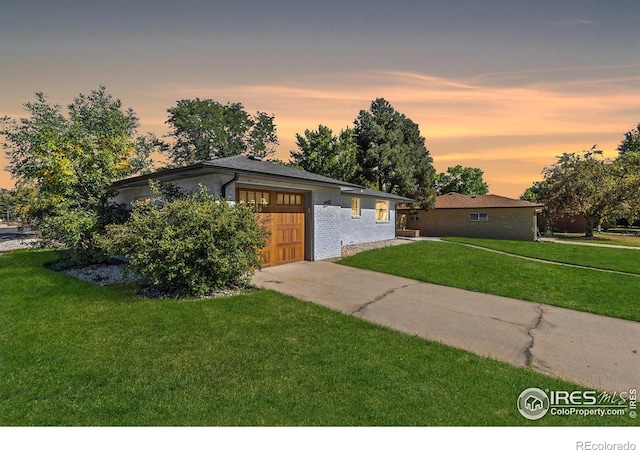 view of front of house featuring a garage and a lawn