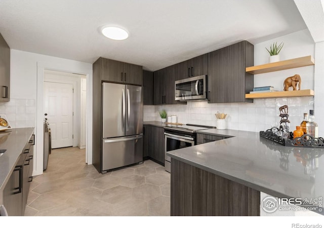 kitchen featuring backsplash, dark brown cabinetry, kitchen peninsula, and appliances with stainless steel finishes