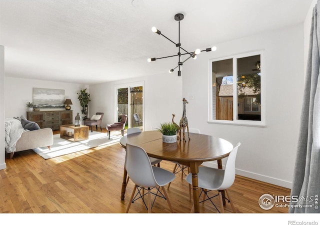 dining area featuring light hardwood / wood-style floors and a notable chandelier