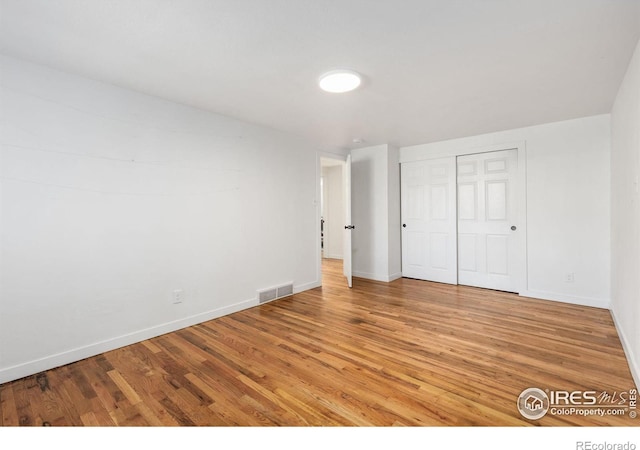 unfurnished bedroom featuring hardwood / wood-style floors and a closet