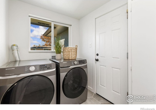 laundry room with light tile patterned flooring and separate washer and dryer