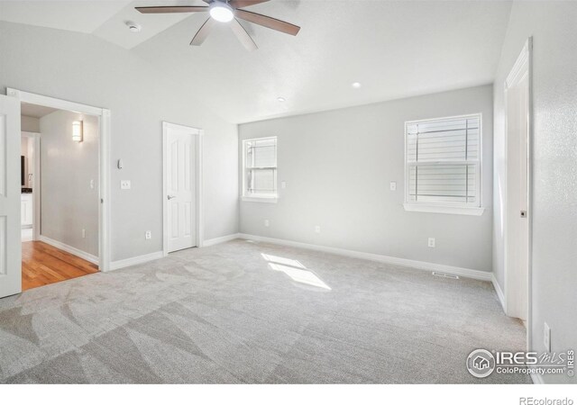 unfurnished bedroom featuring ceiling fan, lofted ceiling, and light carpet