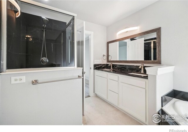 bathroom featuring vanity and independent shower and bath