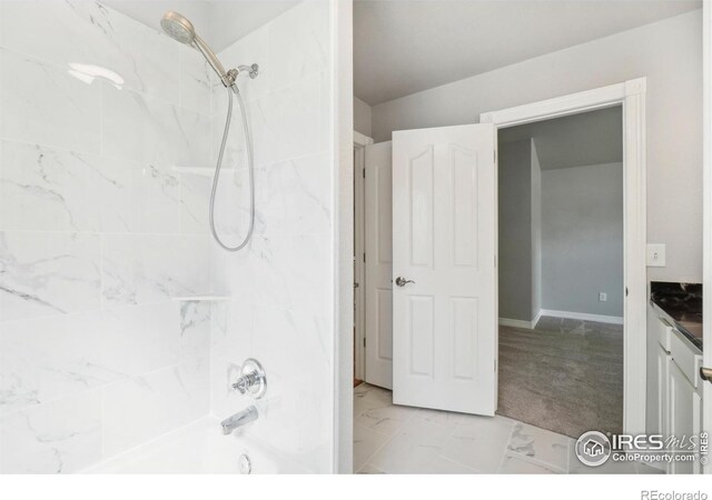 bathroom with vanity and tiled shower / bath