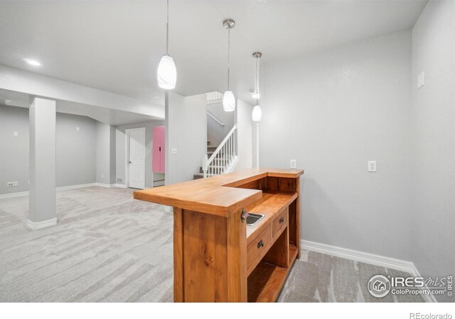 kitchen with light carpet, pendant lighting, and butcher block countertops