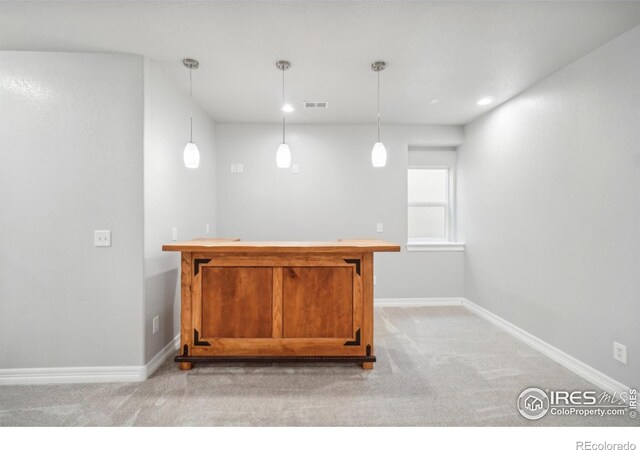 bar with light colored carpet and decorative light fixtures