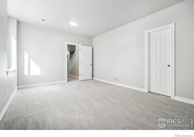 spare room featuring light colored carpet